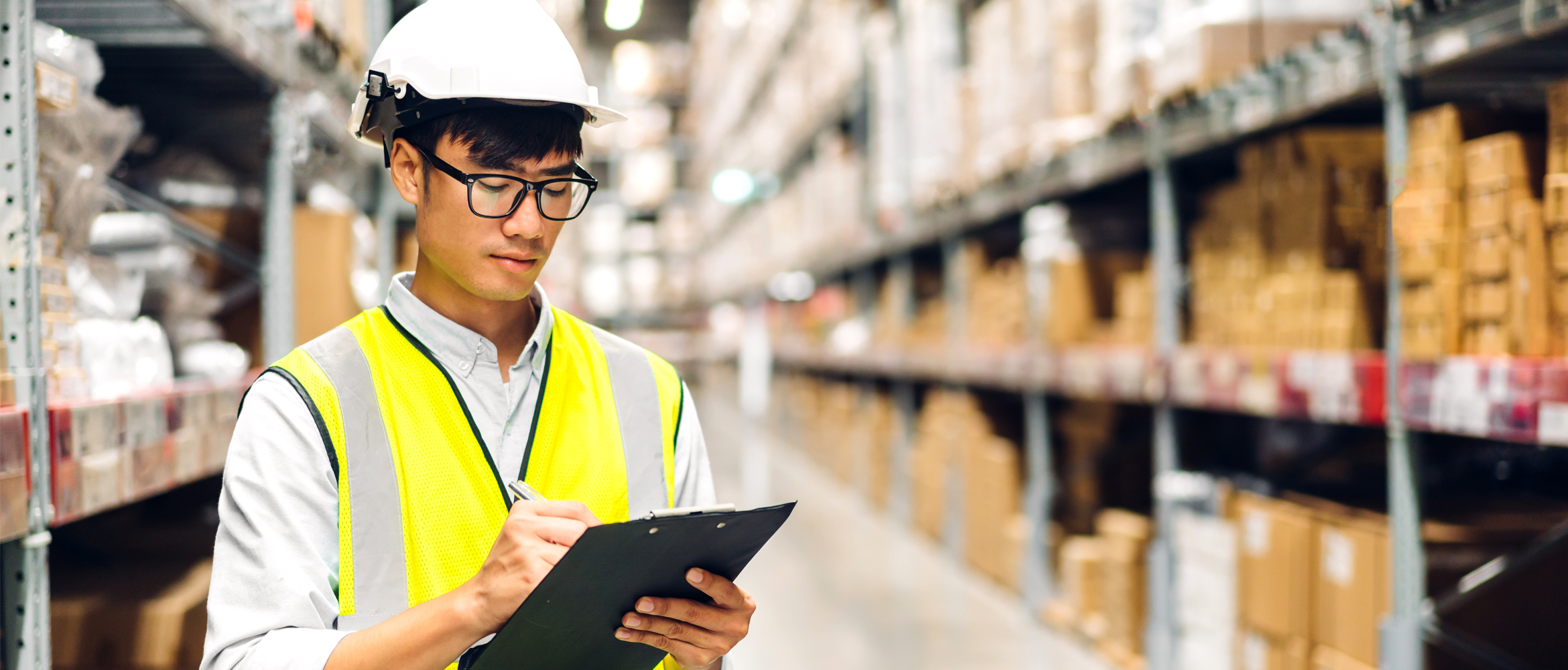 A warehouse worker organizing shipment details of the cargo in a warehouse.