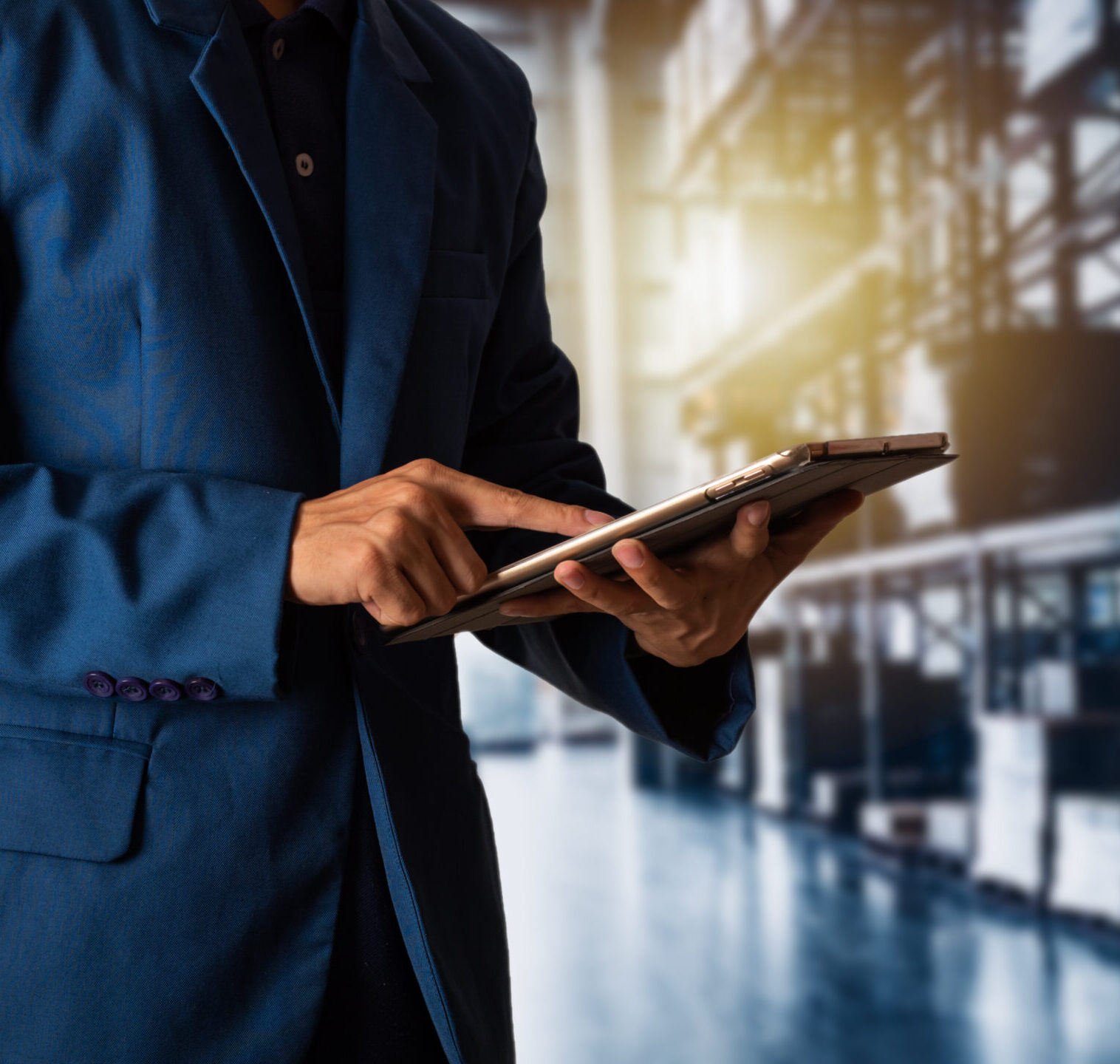 A professional in a suit viewing a tablet for shipment visibility. 