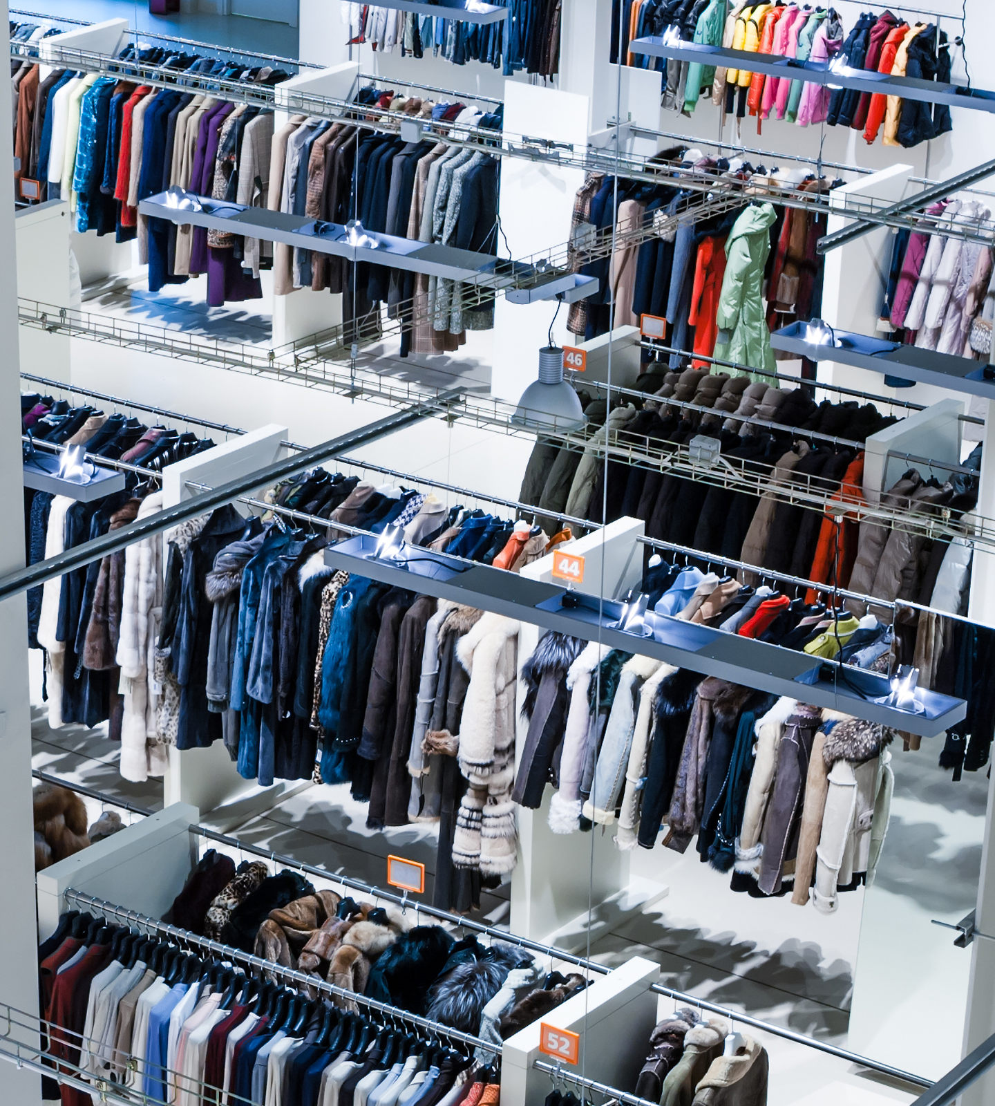 A retail store full of clothing racks displaying a diverse range of apparel.