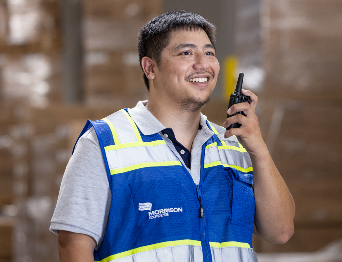 A Morrison warehouse employee communicating with a walkie-talkie. 