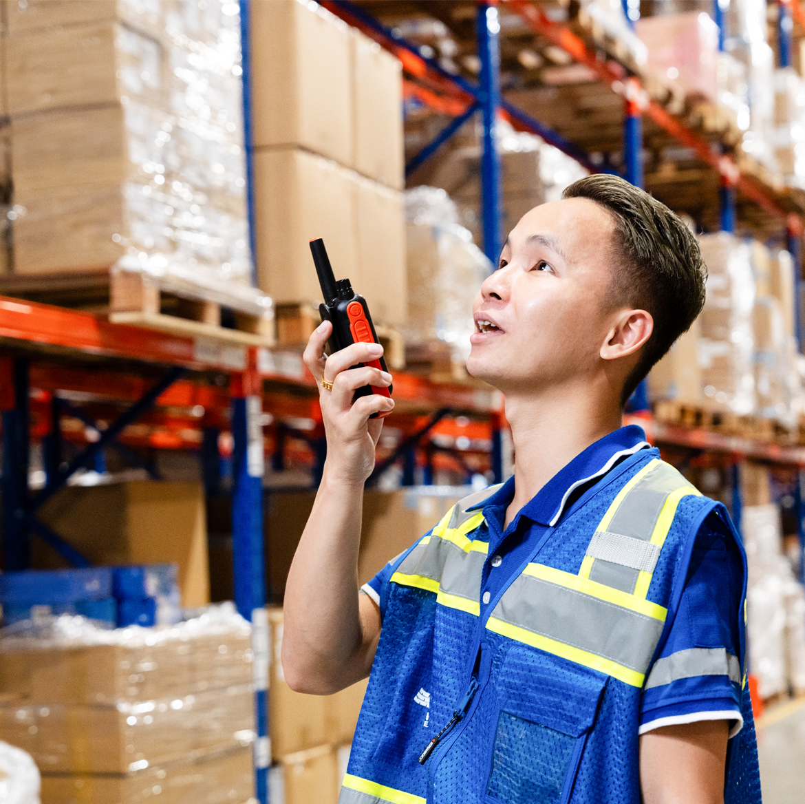 A Morrison warehouse employee comunicating on a walkie-talkie to coordinate security at the warehouse. 