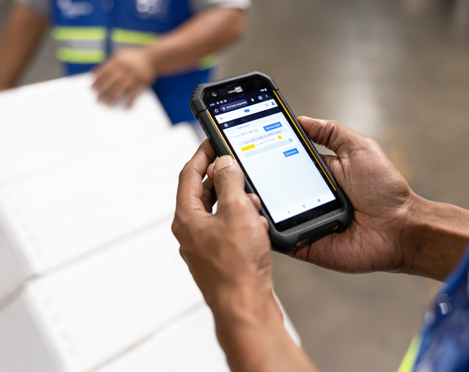 A Morrison warehouse worker tracking a shipment on Morrison One platform using a mobile phone. 