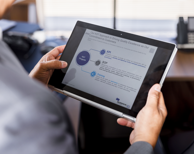 A Morrison employee viewing a tablet with Morrison's Operational  Excellence measures.