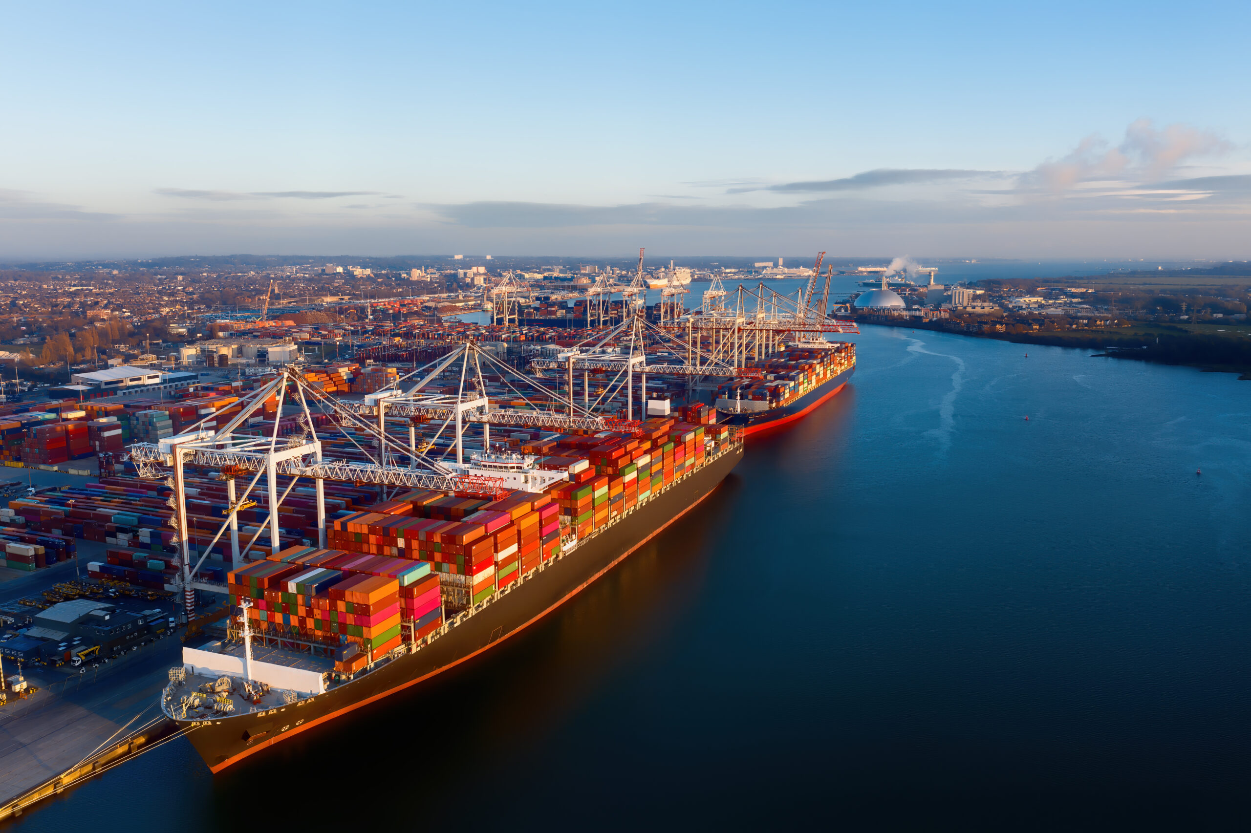 A cargo ship carrying lots of containers sailing on the water.