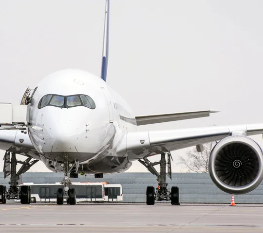A B777 passenger aircraft parked on airport runway.