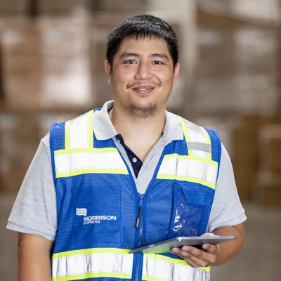 A Morrison warehouse employee smiling while in the warehouse. 