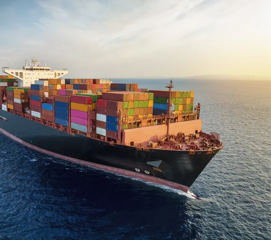 A large cargo ship carrying containers and goods, crossing the ocean.