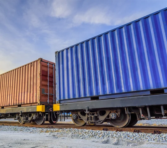 A freight train transporting cargo containers along the tracks.