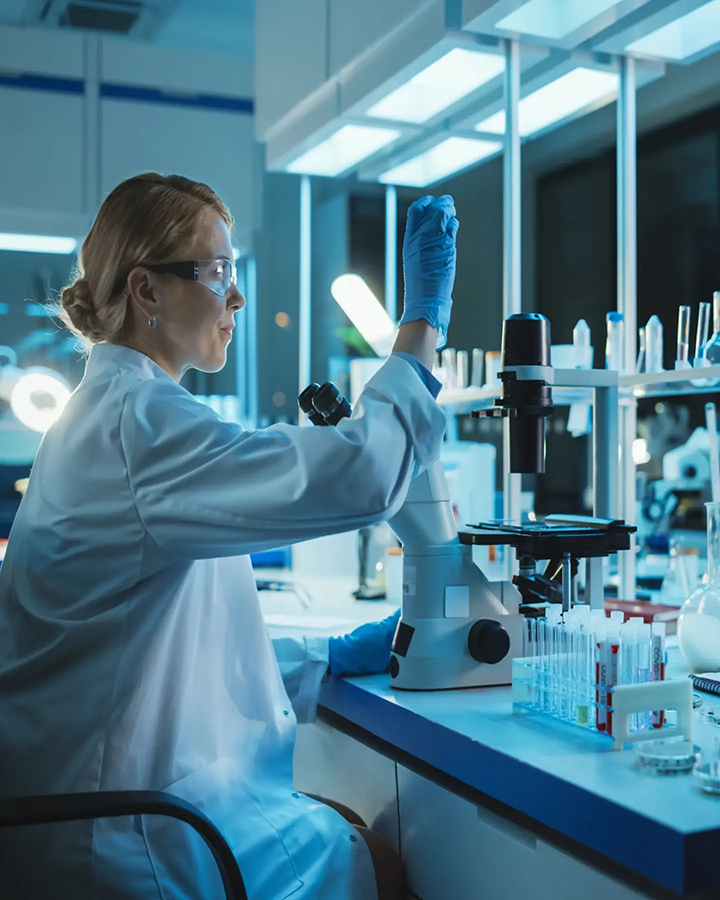 A healthcare scientist in a laboratory, examining a specimen.