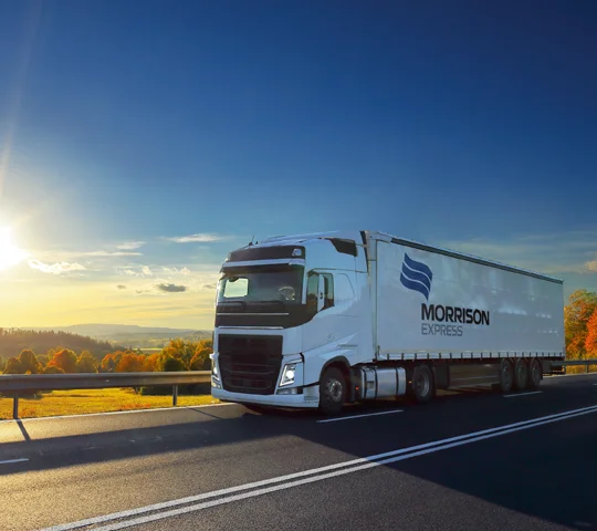 A Morrison branded semi-trailer truck driving on the highway.